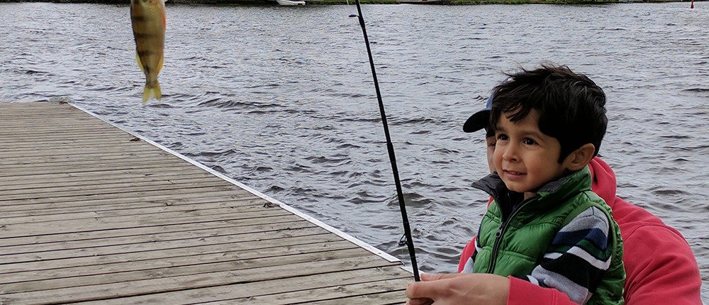 A young boy and his father on the dock with their catch of the day
