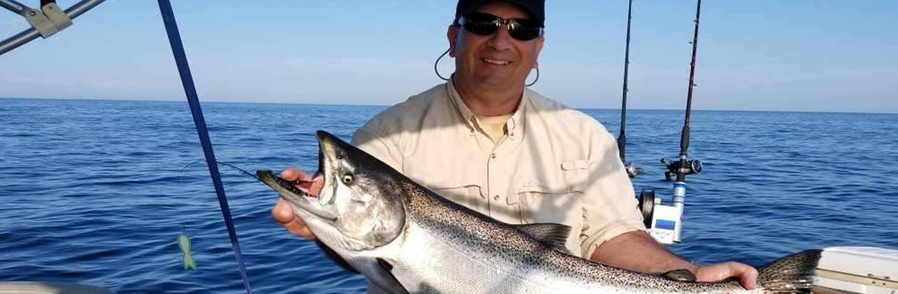 Dr John Dettmers holding a salmon caught in July 2019