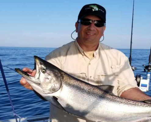 Dr John Dettmers holding a salmon caught in July 2019